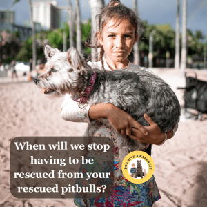 A young girl holds a small dog while looking at the reader